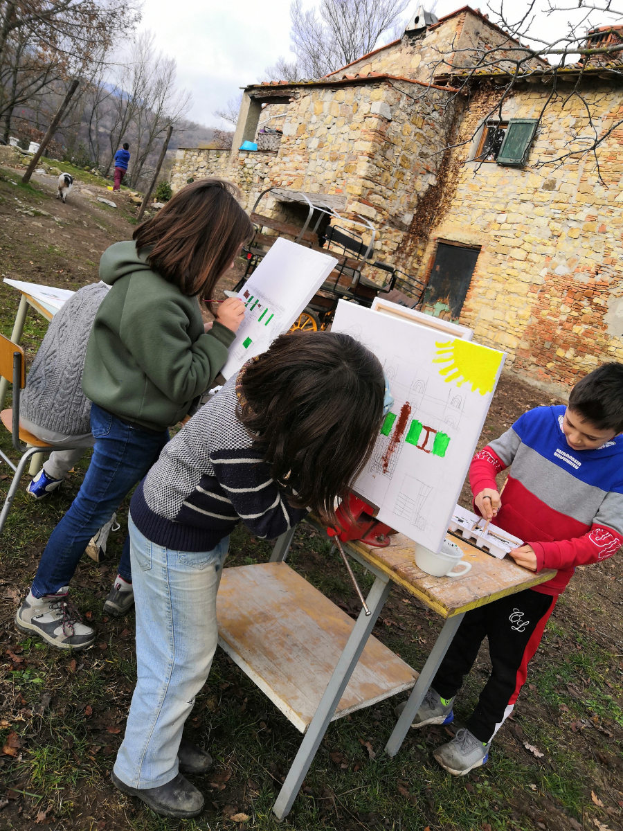 1 Bambini impegnati in un laboratorio creativo all’aperto, in un contesto naturale che valorizza esperienza, autonomia, relazione e apprendimento.